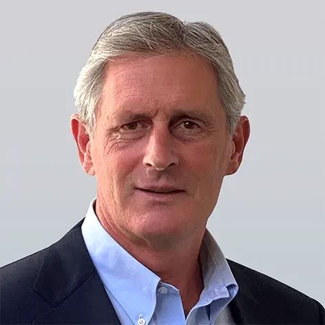 Headshot of John Morrison, a professional with short, light hair, wearing a navy suit and a light blue shirt, smiling at the camera.